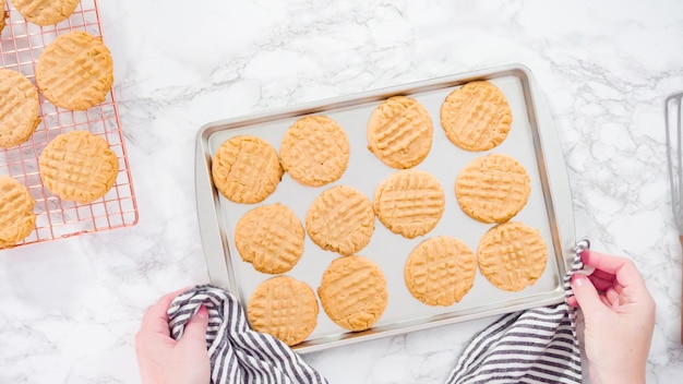 Flat lay. Step by step. Freshly baked peanut butter cookies on baking sheet.