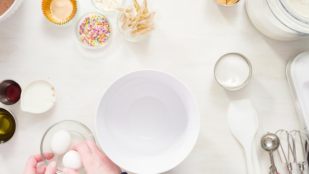 Flat lay. Step by step. Mixing ingredients together in a white mixing bowl to make unicorn chocolate cupcakes with buttercream frosting.