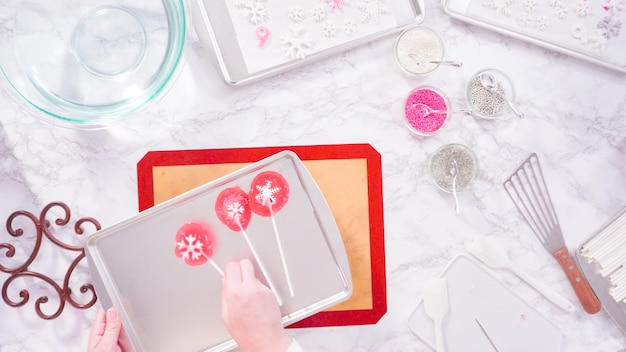 Flat lay. Step by step. Peeling cooled homemade lollipops from silicone baking mats.