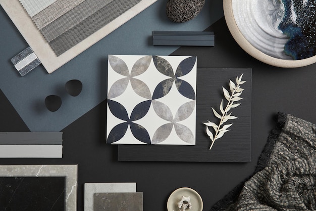 Flat lay of stylish architect moodboard composition with black beige and grey samples of textile paint panels and tiles Top view Copy space Template