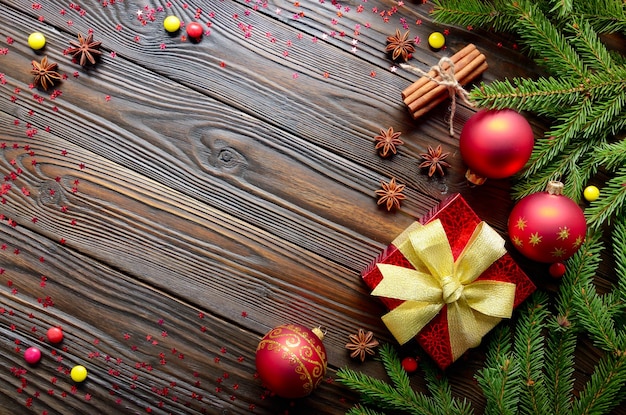 Flat lay top view at Christmas background with red gift box glass balls spices and fir twigs