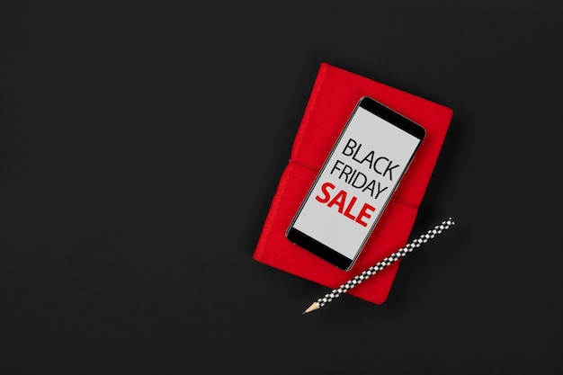 Flat lay top view mockup with smartphone and note pad black friday sale