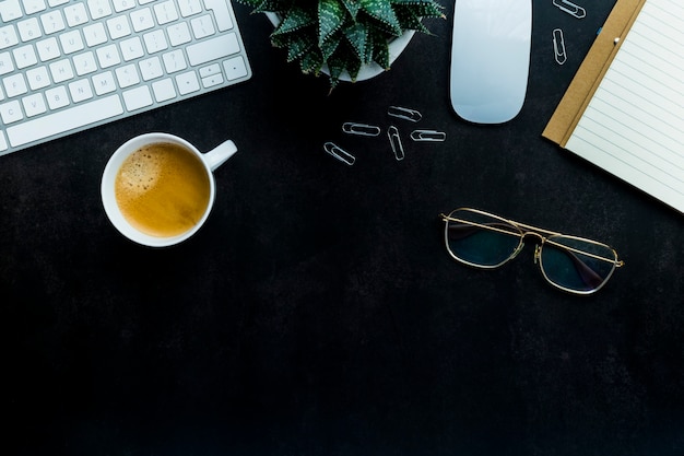 Flat lay top view office desk working space with keyboard and smartphone, watch, plant, coffee