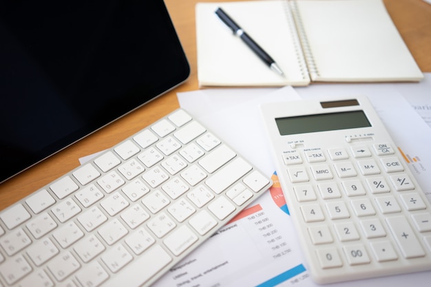 Flat lay of top view office table desk with blank notebook. Calculators and other office