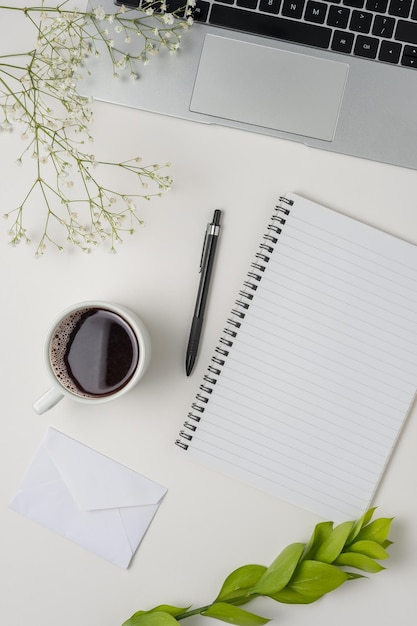 Flat lay top view office table desk Workspace with blank clip board laptop office supplies pencil green leaf and coffee cup on white background