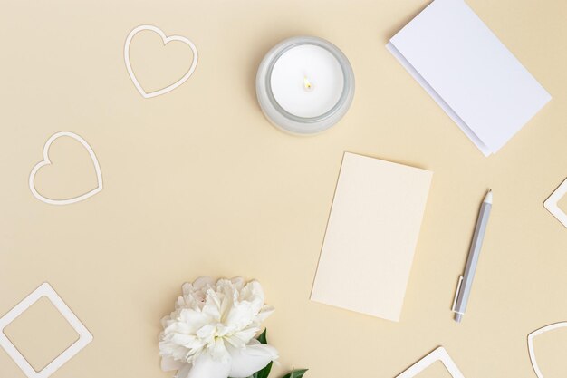 Flat lay top view office table desk Workspace with blank copybook pen white peony flower