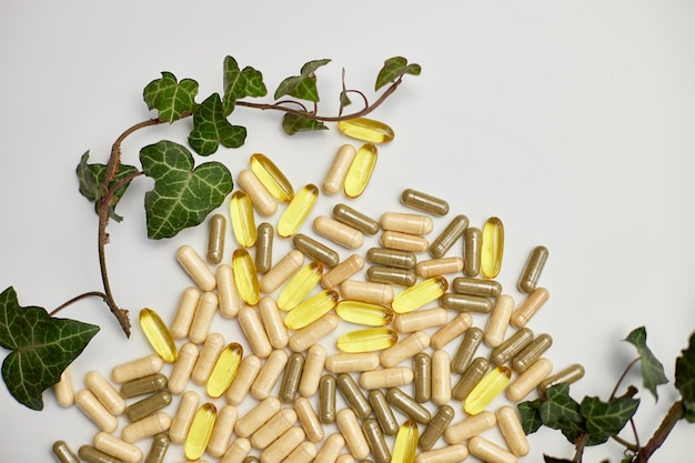 Flat lay top view Pills medical tablets with green plants leaves