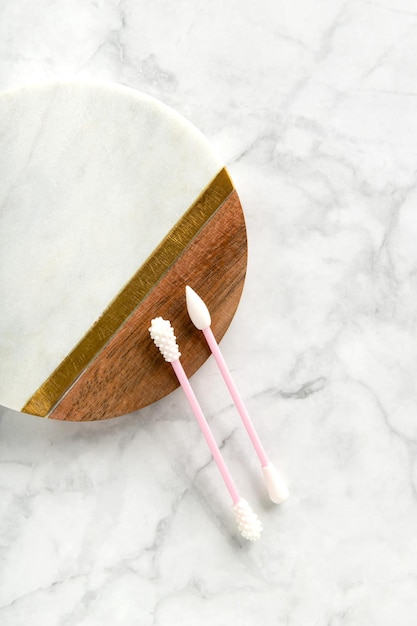 Flat lay top view pink reusable silicone swab buds on white marble background