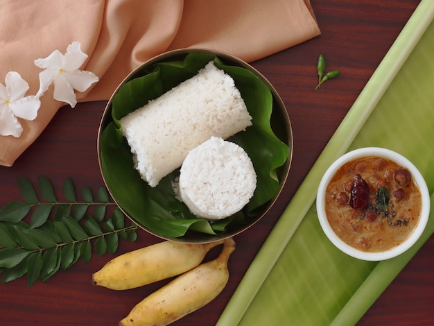 Flat Lay of Traditional Indian Breakfast White Steamed Puttu with Curry and Bananas