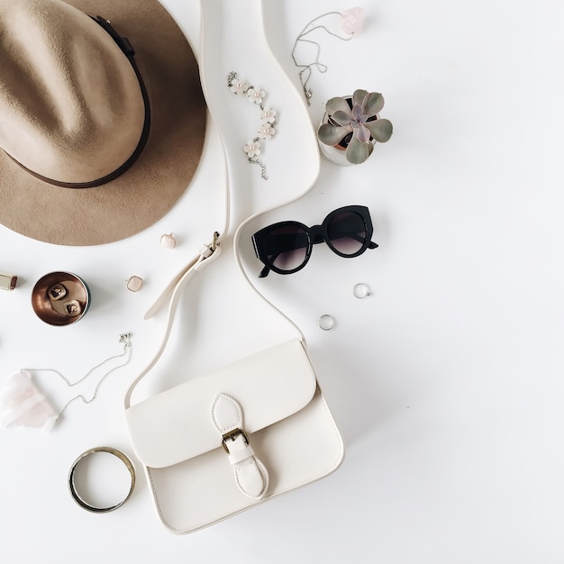 Flat lay trendy creative feminine accessories arrangement. Purse, hat, sunglasses, female accessories.