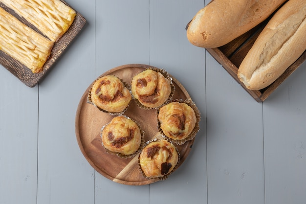 Flat lay of variety of bakery and danish shredded pork on wooden board