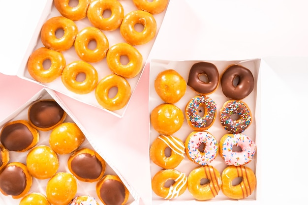 Flat lay Variety of storebought doughnuts in a white paper box