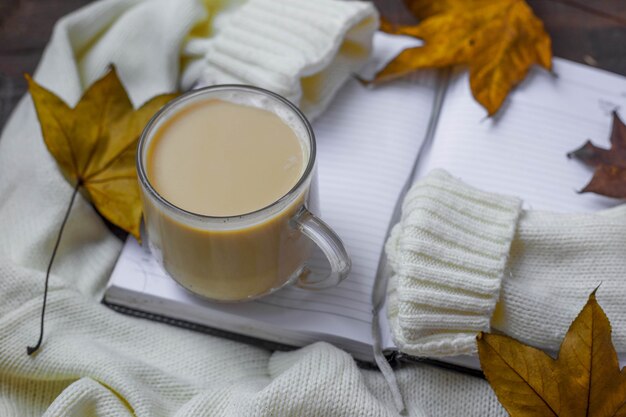 Flat lay with autumn leaves, warm sweater and cup of coffie.