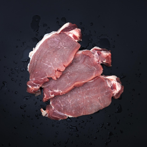 Flat lay with fresh meat on dark background