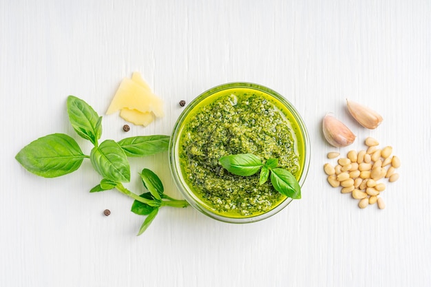 Flat lay with italian organic pesto sauce in bowl made of basil leaf pine nuts garlic and parmesan