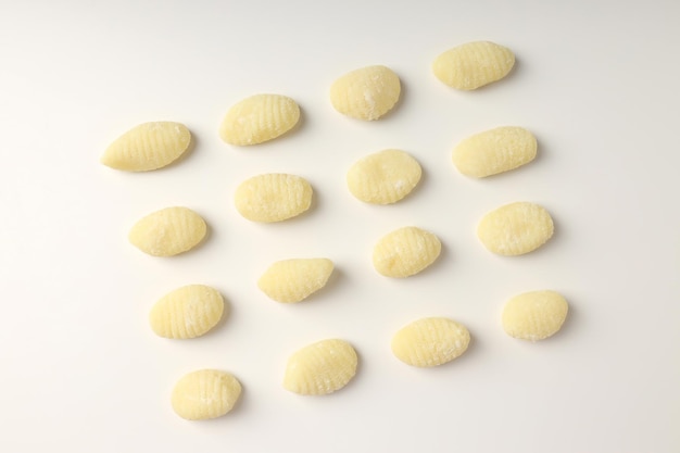 Flat lay with raw potato gnocchi on white background