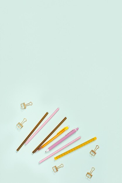 Flat lay with stationery for school or office Pink and golden colored pencils pens