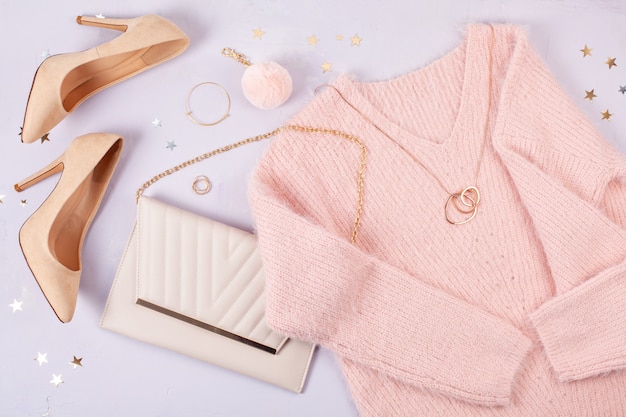 Flat lay of woman clothing and accessories in pastel colors