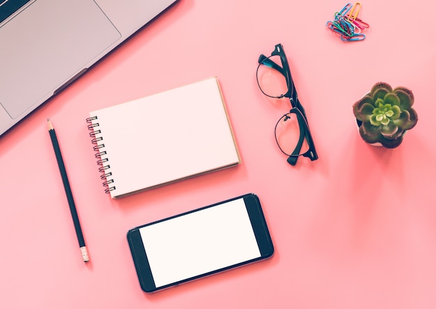 Flat lay  of workspace desk with laptop, blank notebook, smartphone, pencil, stationery with copyspace 