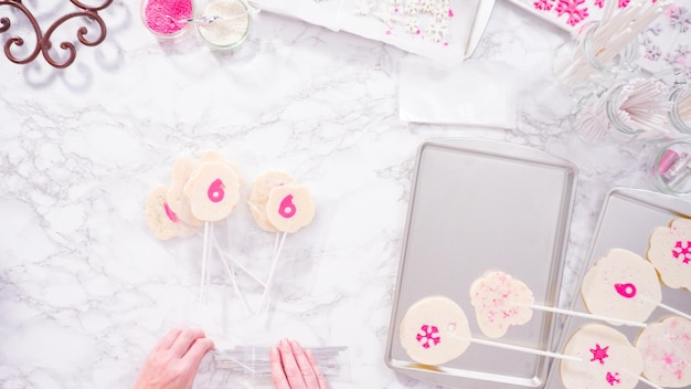 Flat lay. Wrapping large homemade lollipops into clear gift bags.