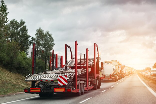 Photo a flatbed tow truck transporting a damaged car on the highway after a collision with another vehicle showing the need for roadside assistance insurance