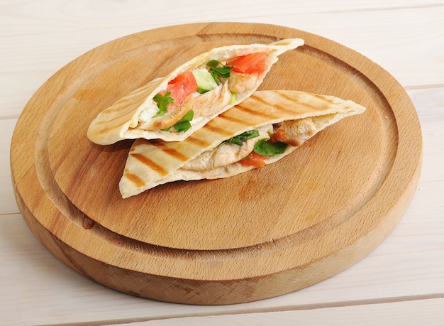 Flatbread pita filled with chicken breast, vegetables and sauce