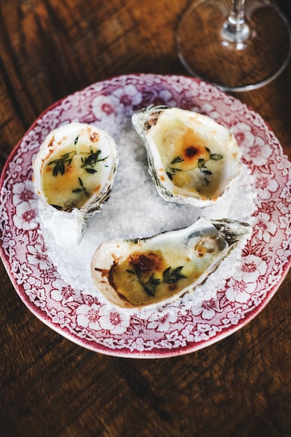 Flatlay of oven baked oysters with parmesan cheese and herbs