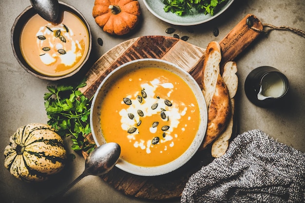 Flatlay of pumpkin soup with seeds fresh parsley and cream