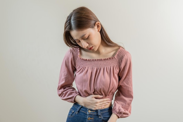 Flatulence young asian woman girl hand in stomach ache suffer from food poisoning abdominal pain and colon problem gastritis or diarrhoea Patient belly abdomen or inflammation concept