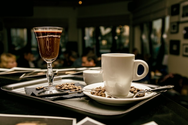 Flatware with coffee glasses and coffee beans in evening cafe