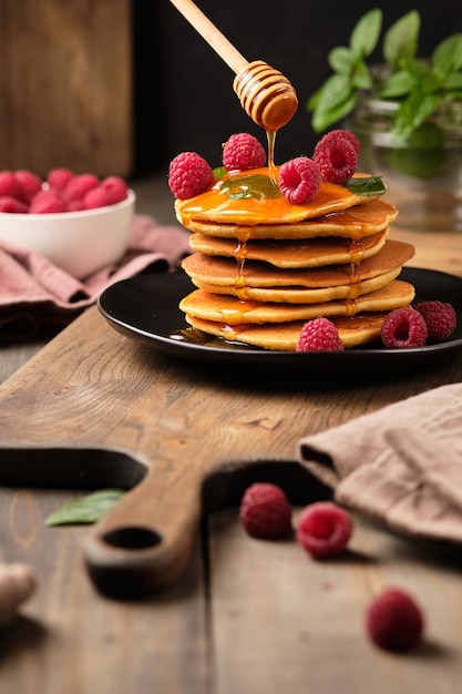 flavored pancakes with honey and fresh raspberries for breakfast