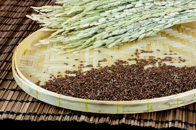 flax seed with raw grain placed on flat woven basket