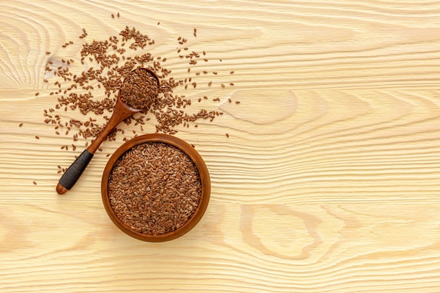 Flax seeds in a spoon and bowl with a bottle of flaxseed oil