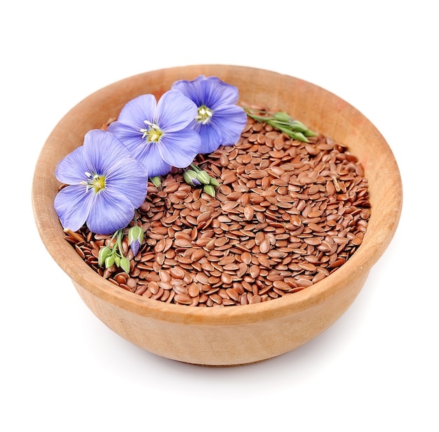 Flax seeds with flowers on the plate isolated.