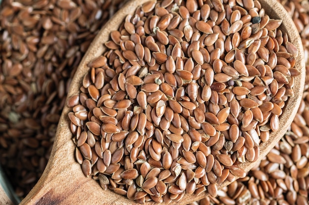 Flax seeds in a wooden spoon on an old table