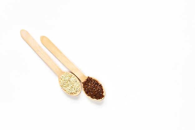 Flax seeds in a wooden spoon on a white background View from above