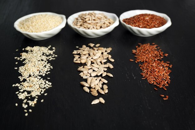 Flax sesame and sunflower seeds on wooden table