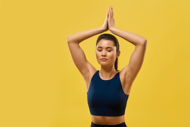 Flexible girl holding prayer hands above head