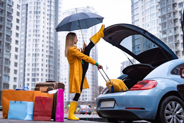 Flexible woman holding split and taking out bags from the car flexibility yoga stretching and health...