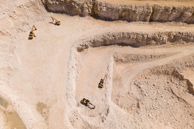 Photo the flight of the drone over a quarry of sand and white stone in the image you can see excavators that are stopped aerial view of the stone and sand industry