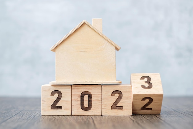 Flip 2022 to 2023 block with house model real estate Home loan tax investment financial savings and New Year Resolution concepts