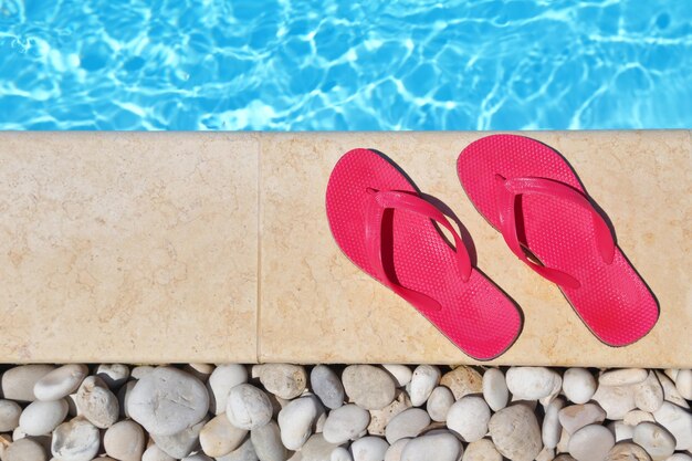 Flip flops by the poolside with water and copyspace