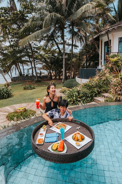 Floating breakfast in infinity pool on paradise swimming pool, morning in the tropical resort bungalow