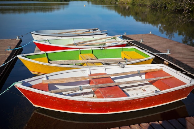 Floating Color Wooden Boats with Paddles in a Lake