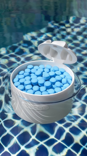 Photo a floating dispenser with pool chlorine tablet pool float and chlorine tablets for pool mntenance