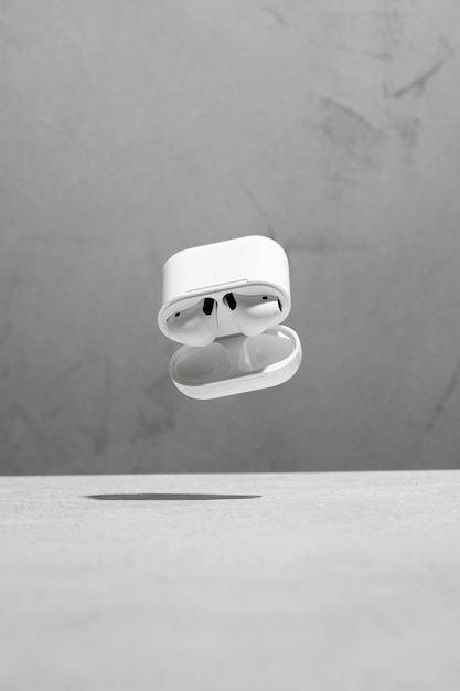 Floating modern wireless earphones with concrete background