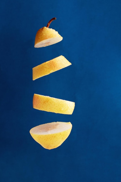 floating pieces of fresh lemon against blue background creative picture