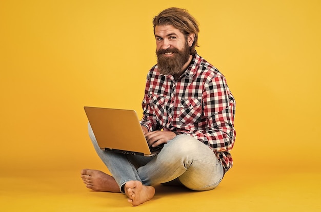 Flood on the internet happy man won in lottery Distance learning feel the success work from home while coronavirus quarantine portrait of hipster man working on his laptop selfisolation