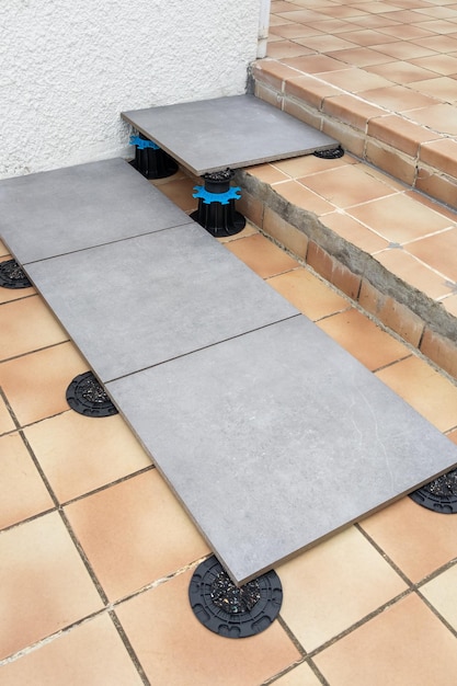 Floor tile with pedestal support with integrated slope plot corrector plastic studs adjustable pads