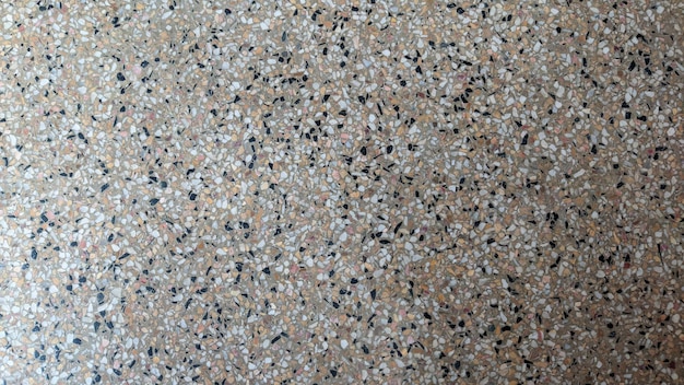 A floor with a pattern of small stones and a white object.